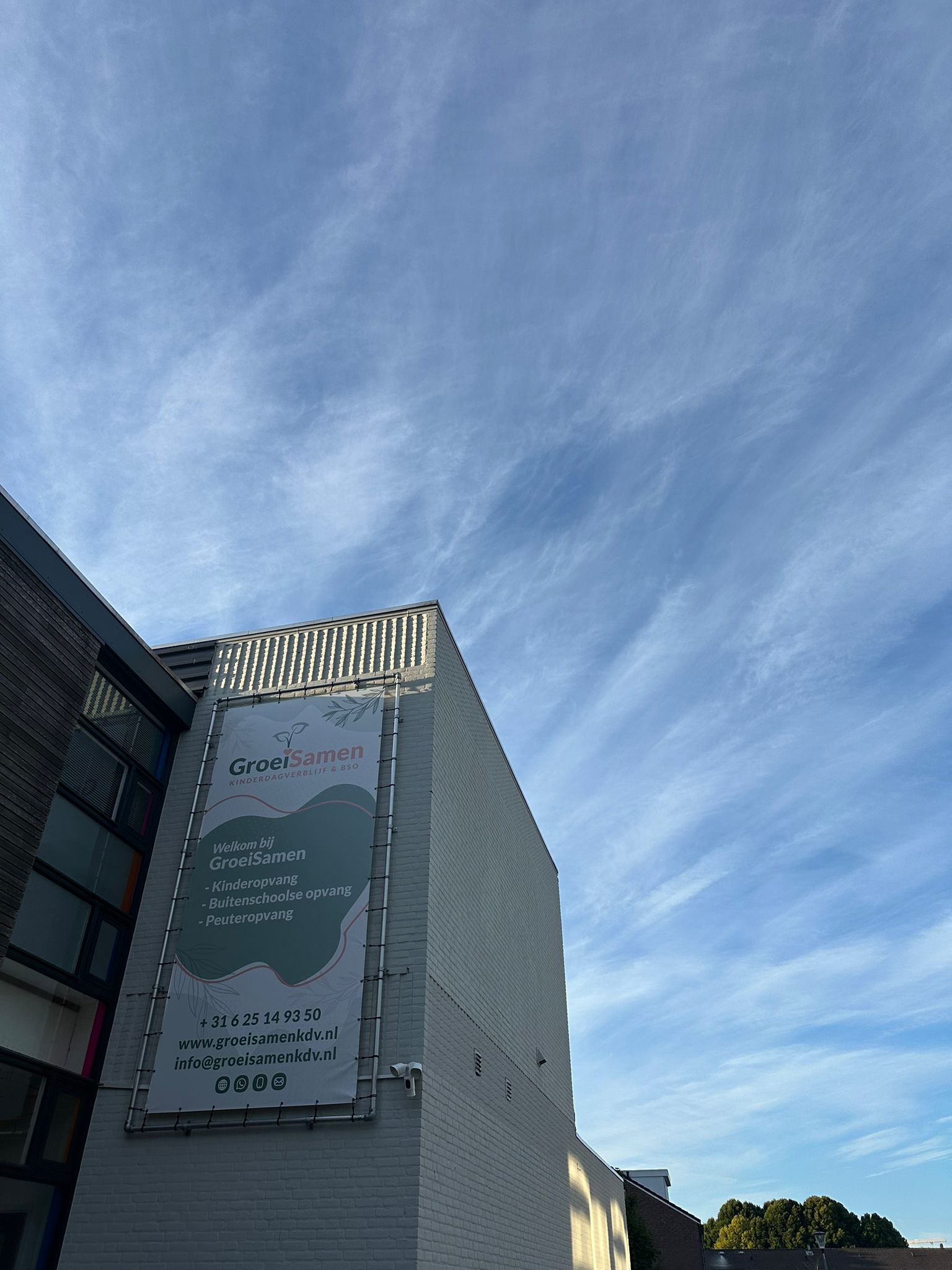 Het gebouw van GroeiSamen Kinderdagverblijf met logo op de houten gevel